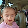 toddler, child, girl, portrait, face, eyes, pigtails, pink_shirt, sitting, car, vehicle, car_interior, car_seat, child_safety_seat, leather_seat, indoors, travel, close_up, serious_expression, photograph