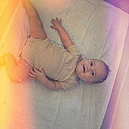 Vander joined the competition — help win amazing prizes! baby, infant, child, smiling, lying_down, crib, mattress, blanket, striped_clothing, onesie, portrait, face, eyes, hands, feet, indoor, nursery, bedtime, colorful_lighting, happy