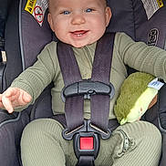 Anthony joined the competition — help win amazing prizes! baby, child, car_seat, seatbelt, green_clothing, plush_toy, avocado_toy, smiling, blue_eyes, infant, happy, cute, sitting, child_safety, car_travel, toddler, face, person, indoor, closeup