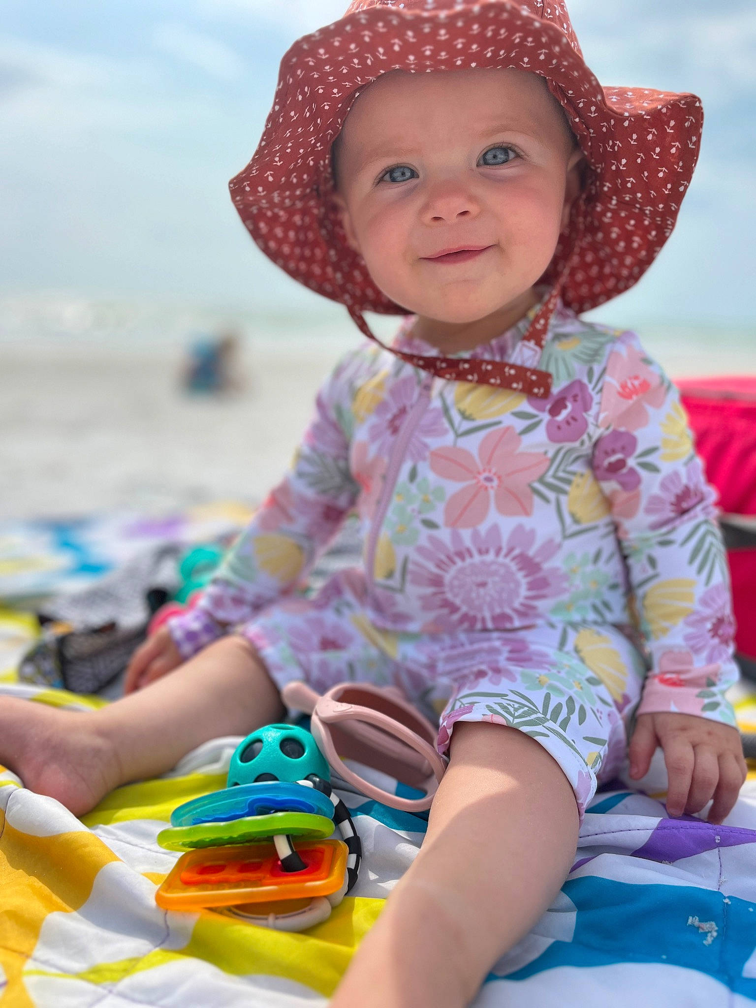 Elena is registered to the contest to win money with this photo: baby_toddler_clothing, beach, blue, body_of_water, child, facial_expression, fun, happy, hat, headgear, headwear, joy, leisure, people_on_beach, person, photograph, skin, sky, smile, summer