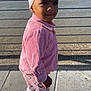 child, toddler, pink_clothing, headband, outdoor, river, cityscape, sidewalk, shadow, building, water, daylight, fashion, portrait, young_child, casual_wear, footwear, urban, smiling, person