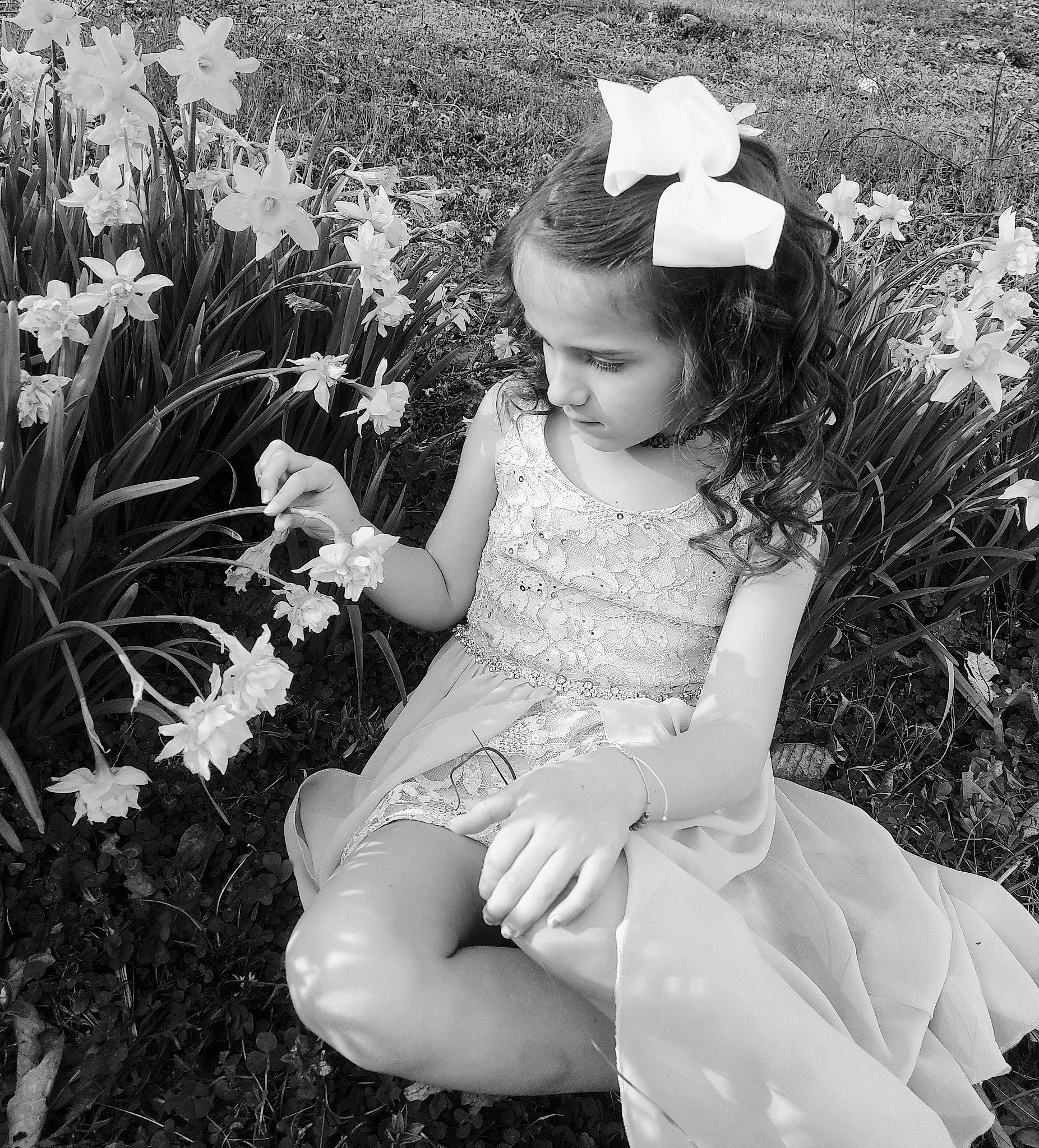 Haley is registered to the contest to win money with this photo: black, black_and_white, botany, dress, eye, facial_expression, flower, hand, happy, head, human_body, iris, leaf, organ, people_in_nature, person, petal, photograph, plant, standing