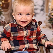 Hudson is registered to the contest to win money with this photo: blonde_hair, blue_jeans, casual_clothing, chair, child, cute, face, festive, happy, holiday_background, indoor, person, plaid_shirt, portrait, seated, smiling, toddler, warm_lighting, wooden_chair, young_child