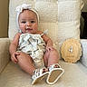 baby, child, infant, headband, bow, chair, plush, soft_texture, wooden_plaque, months_marker, white_sandals, smiling, cute, comfortable, indoors, portrait, happy, sitting, clothing, person