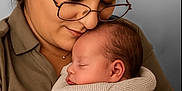 Clément participe au concours pour gagner de l'argent avec cette photo : woman, baby, sleeping, glasses, blanket, hug, affection, love, tenderness, portrait, closeup, face, hand, cozy, warm, indoor, family, motherhood, skin, clothing