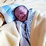 Clément participe au concours pour gagner de l'argent avec cette photo : baby, newborn, blanket, pillow, sleeping, smiling, wrapped, infant, cozy, soft, patterned_blanket, yellow_blanket, blue_pillow, resting, indoors, cute, peaceful, baby_clothes, head, face