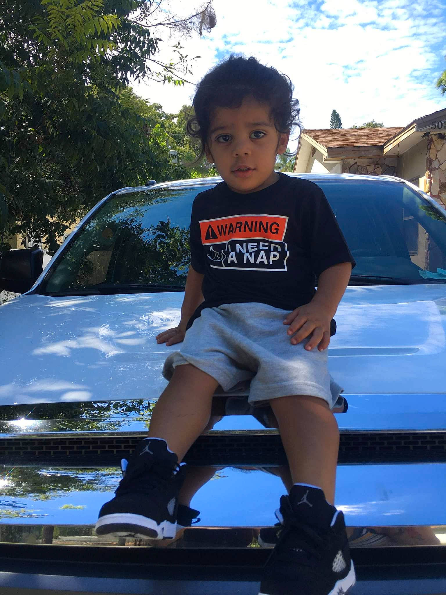 Julian joined the competition — help win amazing prizes! automotive_design, automotive_exterior, automotive_lighting, automotive_tire, blue, bumper, car, flash_photography, grille, hairstyle, headlamp, hood, human_body, land_vehicle, leg, motor_vehicle, person, shorts, sky, vehicle