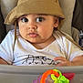 baby, child, bucket_hat, high_chair, toy, drool, curious, indoor, face, clothing, plastic_toy, grape_toy, green_leaf, orange_ring, purple_toy, person, sitting, closeup, expression, cute
