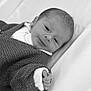 baby, newborn, infant, black_and_white, knitted_sweater, blanket, hand, face, portrait, sleeping, soft_texture, cozy, cute, person, young_child, indoors, closeup, resting, small, peaceful