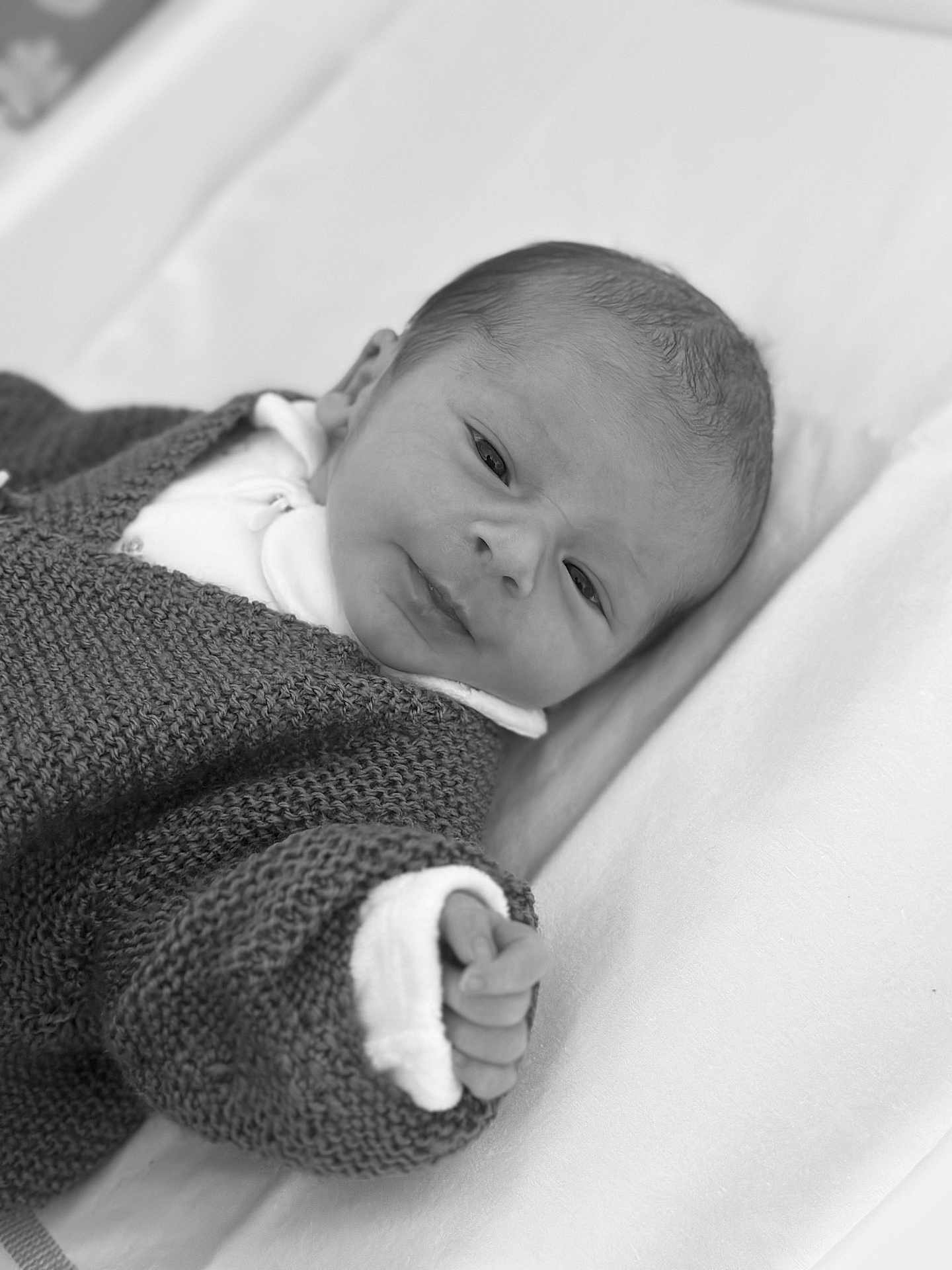 Malo participe au concours pour gagner de l'argent avec cette photo : baby, newborn, infant, black_and_white, knitted_sweater, blanket, hand, face, portrait, sleeping, soft_texture, cozy, cute, person, young_child, indoors, closeup, resting, small, peaceful