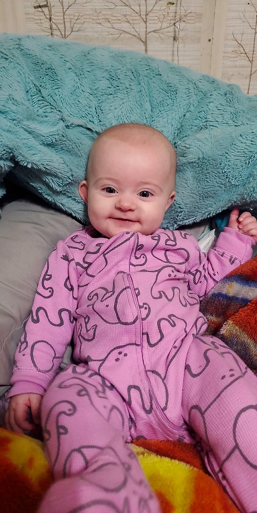 Maci is registered to the contest to win money with this photo: baby, baby_toddler_clothing, cheek, comfort, eye, facial_expression, human, iris, lip, mouth, nose, organ, outerwear, person, pink, product, purple, skin, sleeve, smile