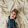 Odayah is registered to the contest to win money with this photo: baby, child, smiling, headband, bow, denim_overalls, white_shirt, blanket, textured_blanket, infant, happy, portrait, lying_down, cute, indoors, person, clothing, face, expression, skin