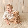 Maddison joined the competition — help win amazing prizes! baby, child, teddy_bear, smile, blue_eyes, white_clothing, fluffy_rug, wooden_background, cute, sitting, indoors, soft_light, portrait, happy, infant, toy, cozy, warm, candid, playful
