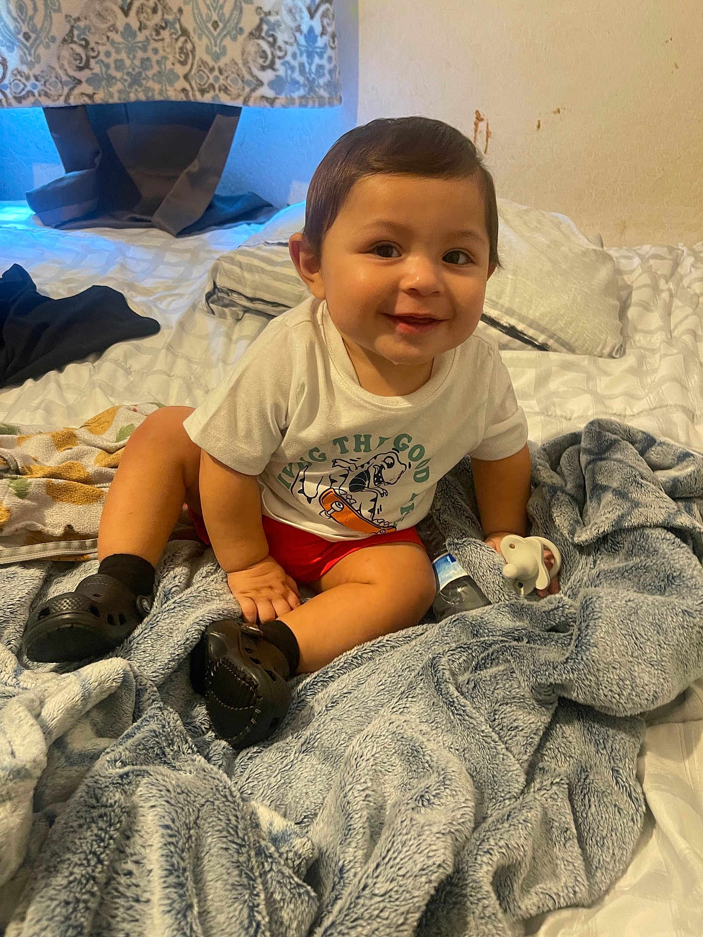 Javier joined the competition — help win amazing prizes! baby, bed, bedroom, blanket, clothing, face, footwear, furniture, happy, head, indoors, pants, person, photography, portrait, quilt, room, shoe, smile, t_shirt
