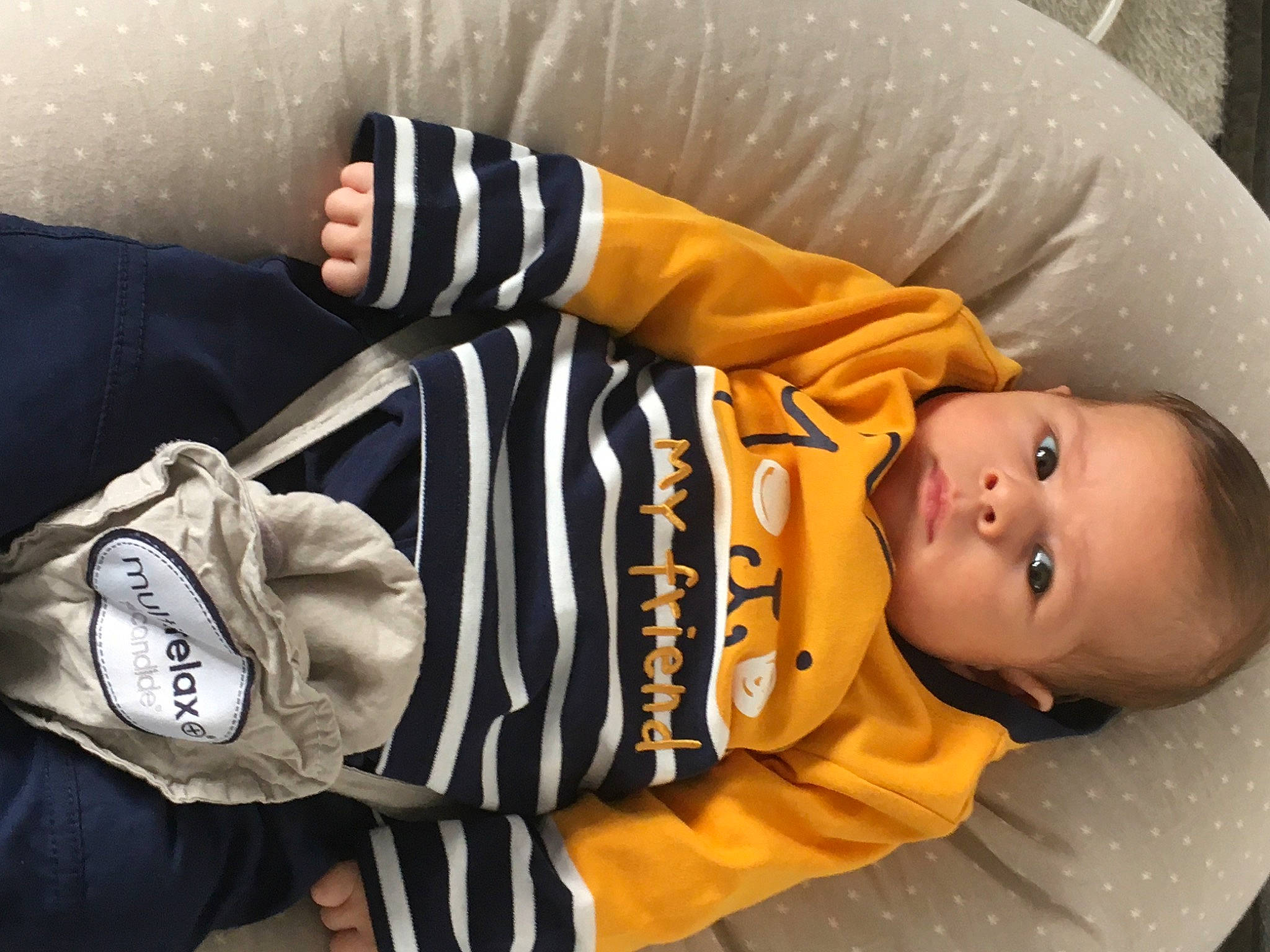 Enzo a rejoint le concours — aidez-le/la à gagner de superbes lots ! baby, baby_products, baby_safety, baby_toddler_clothing, backpack, bag, child, comfort, gesture, luggage_and_bags, orange, person, product, sitting, sleeve, smile, toddler