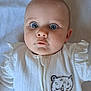 Hattie is registered to the contest to win money with this photo: adorable, baby, baby_outfit, background_blanket, blue_eyes, child, closeup, curious_expression, cute, face, head, infant, person, portrait, skin, sleepy_cat_illustration, soft_texture, text_on_clothing, white_clothing, young