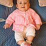Hattie is registered to the contest to win money with this photo: baby, blue_quilt, child, comfortable, cozy, cute, indoors, infant, knitted_clothing, person, pillows, pink_sneakers, pink_sweater, portrait, relaxed, sitting, small_shoes, smiling, soft_texture, white_pants