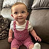 baby, child, infant, sitting, smiling, portrait, indoor, couch, sofa, leather, cushions, blanket, overalls, pink_clothing, polka_dots, white_shirt, white_socks, brown_hair, happy, living_room