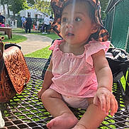 Yazlyn joined the competition — help win amazing prizes! baby, child, pink_dress, hat, sunlight, lens_flare, picnic_table, outdoor, park, people, trees, grass, curious, sitting, footwear, hand, face, summer, daytime, expression