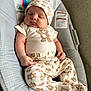 baby, sleeping, teddy_bear, hat, onesie, baby_seat, cushion, infant, cute, peaceful, child, indoors, soft_lighting, comfortable, patterned_clothing, headwear, resting, newborn, plush, portrait