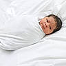 newborn, baby, swaddled, white_blanket, infant, bed, soft, sleeping_area, portrait, cute, child, face, hair, resting, peaceful, cozy, small, wrapped, lying_down, indoors