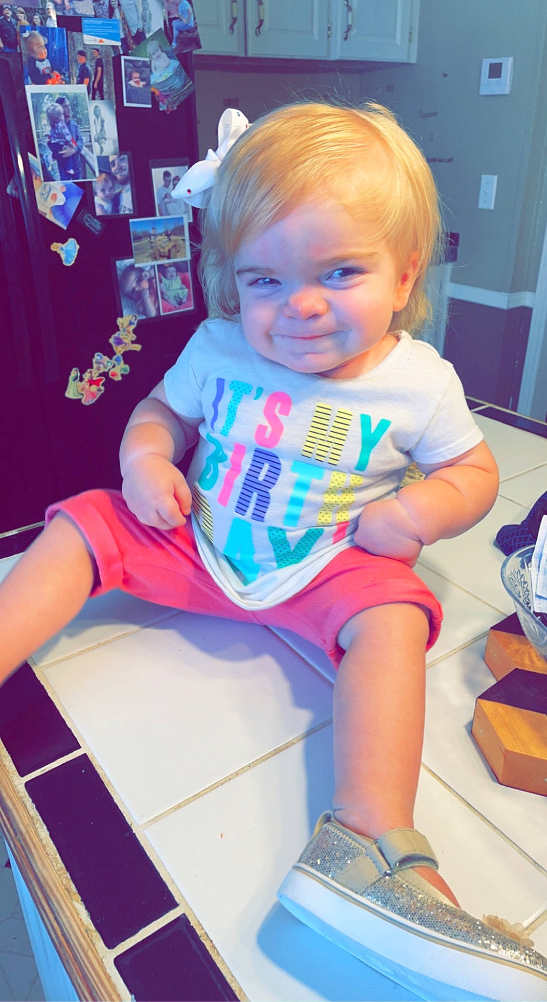 Everly is registered to the contest to win money with this photo: baby, baby_toddler_clothing, cheek, child, electric_blue, fun, hairstyle, happy, human_leg, lap, magenta, person, pink, play, shorts, sitting, smile, sock, t_shirt, thigh