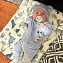 baby, baby_boy, bear_ears, blanket, blue_outfit, child, comfortable, cute, dinosaur_pattern, hat, headwear, indoor, infant, lying_down, mickey_mouse, pacifier, portrait, sleepwear, socks, soft_texture