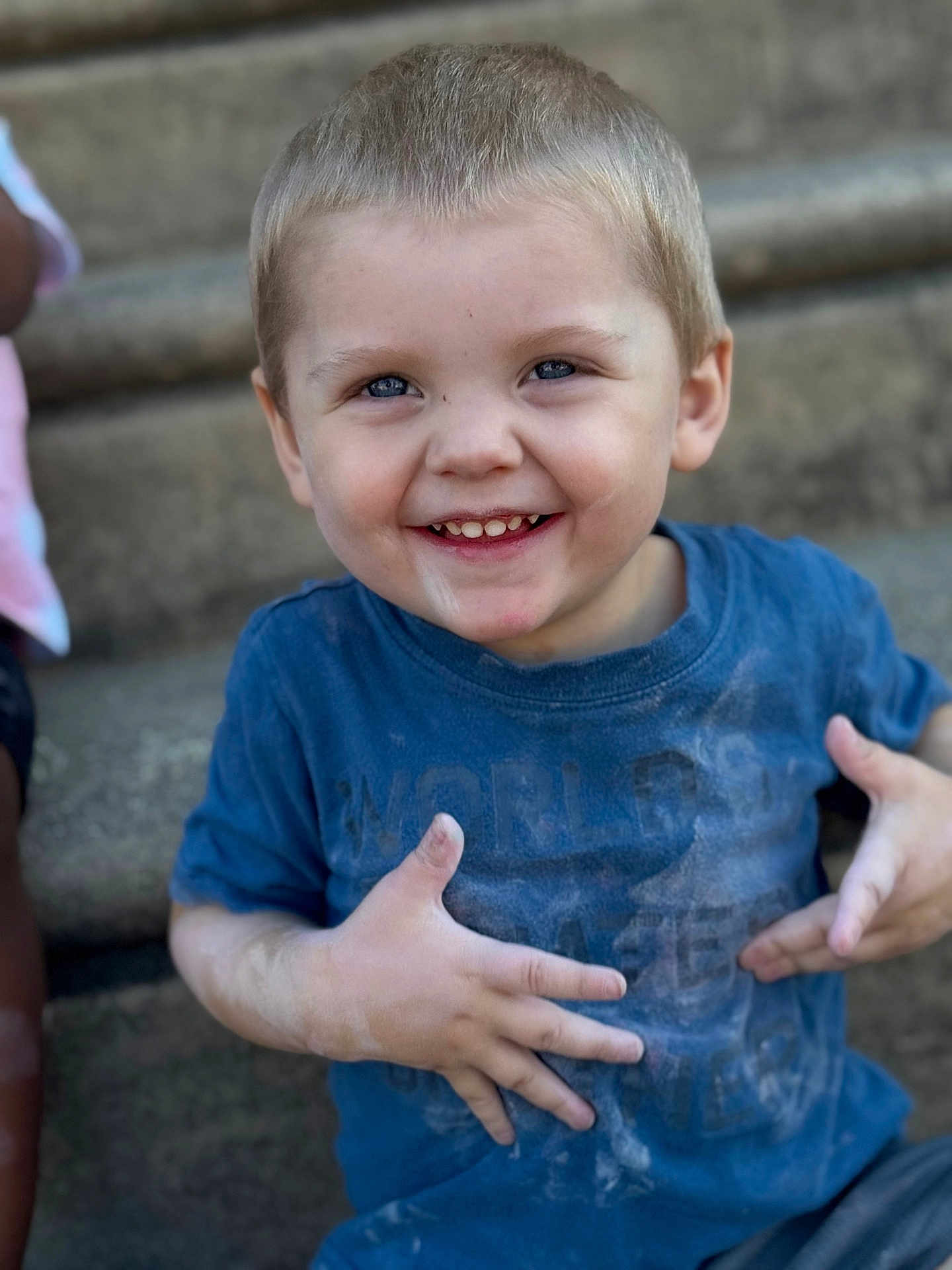 Jaxon is registered to the contest to win money with this photo: child, boy, smiling, blue_shirt, dusty, hands, face, short_hair, outdoor, steps, happy, casual_clothing, portrait, cute, playful, daylight, young, person, skin, expression