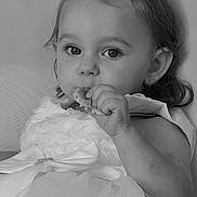 Kamèlya a rejoint le concours — aidez-le/la à gagner de superbes lots ! toddler, child, dress, bow, snack, eating, portrait, black_and_white, closeup, face, hand, curly_hair, earring, cute, indoor, soft_light, young_child, person, baby, apparel