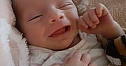 Zariah is registered to the contest to win money with this photo: baby, infant, smile, blanket, soft, cozy, cute, newborn, sleepy, hand, face, clothing, striped, happy, peaceful, closeup, child, portrait, warm, resting