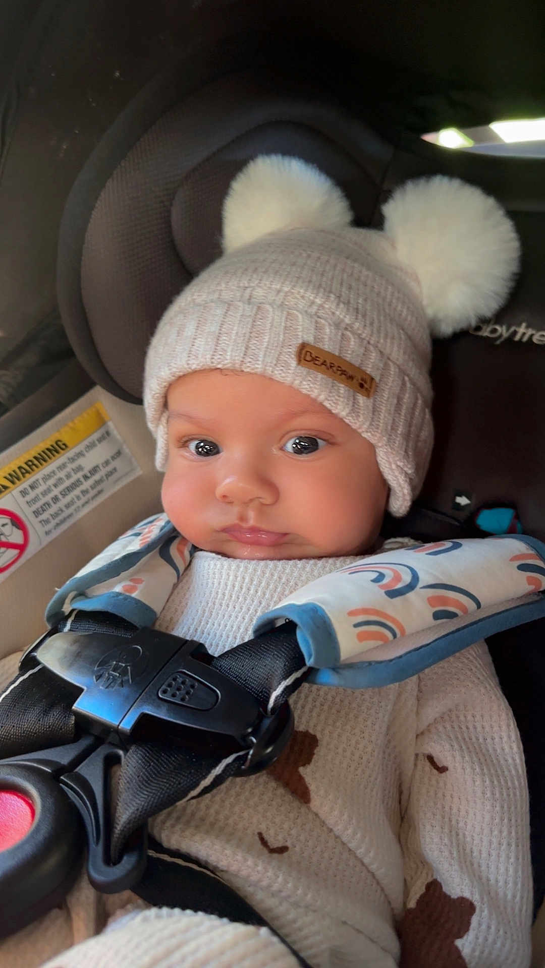 Kobe is registered to the contest to win money with this photo: baby, child, infant, car_seat, hat, knit_hat, pom_poms, straps, clothing, cute, face, eyes, warm, seatbelt, safety, indoors, portrait, expression, cozy, person
