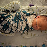 Odysseus is registered to the contest to win money with this photo: newborn, baby, swaddled, blanket, sleeping, nasal_tube, bed, pattern, infant, cute, resting, soft, baby_bed, cozy, head, face, child, hospital, medical, peaceful