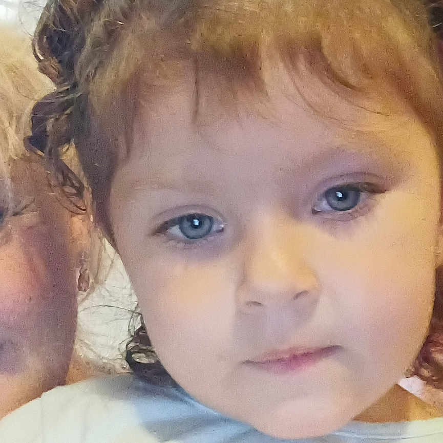 Emberlee Clements is registered to the contest to win money with this photo: blue_eyes, cartoon, casual_clothing, child, childhood, closeup, curly_hair, curtain, cute, expression, eyelashes, face, hair_buns, human, indoor, person, portrait, shirt, smile, young