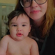 Kaedyn is registered to the contest to win money with this photo: baby, child, closeup, crisp, cute, diaper, face, family, glasses, hair, head, holding, indoor, parent, person, portrait, seated, skin, smile, woman