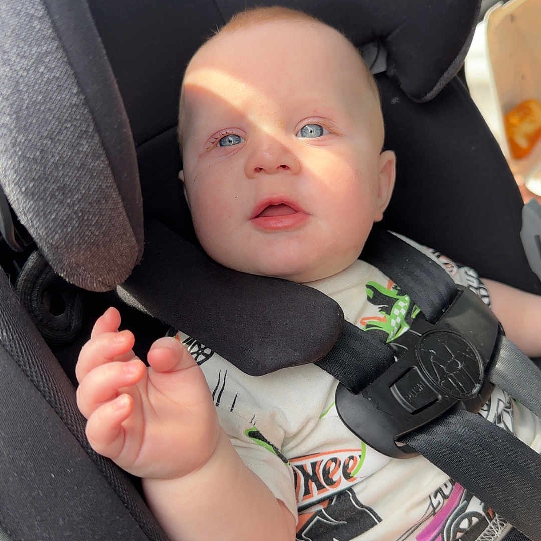 Krew is registered to the contest to win money with this photo: accessories, baby, belt, bodypart, car, car_interior, carseat, clothing, cushion, face, finger, hand, head, homedecor, person, photography, portrait, t_shirt, transportation, vehicle