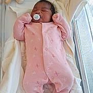 Nelly-Phanuana a rejoint le concours — aidez-le/la à gagner de superbes lots ! baby, newborn, crib, blanket, onesie, pink_clothing, pacifier, sleeping, teddy_bear, soft_toy, nursery, infant, cute, cozy, indoor, child, person, resting, fabric, bed