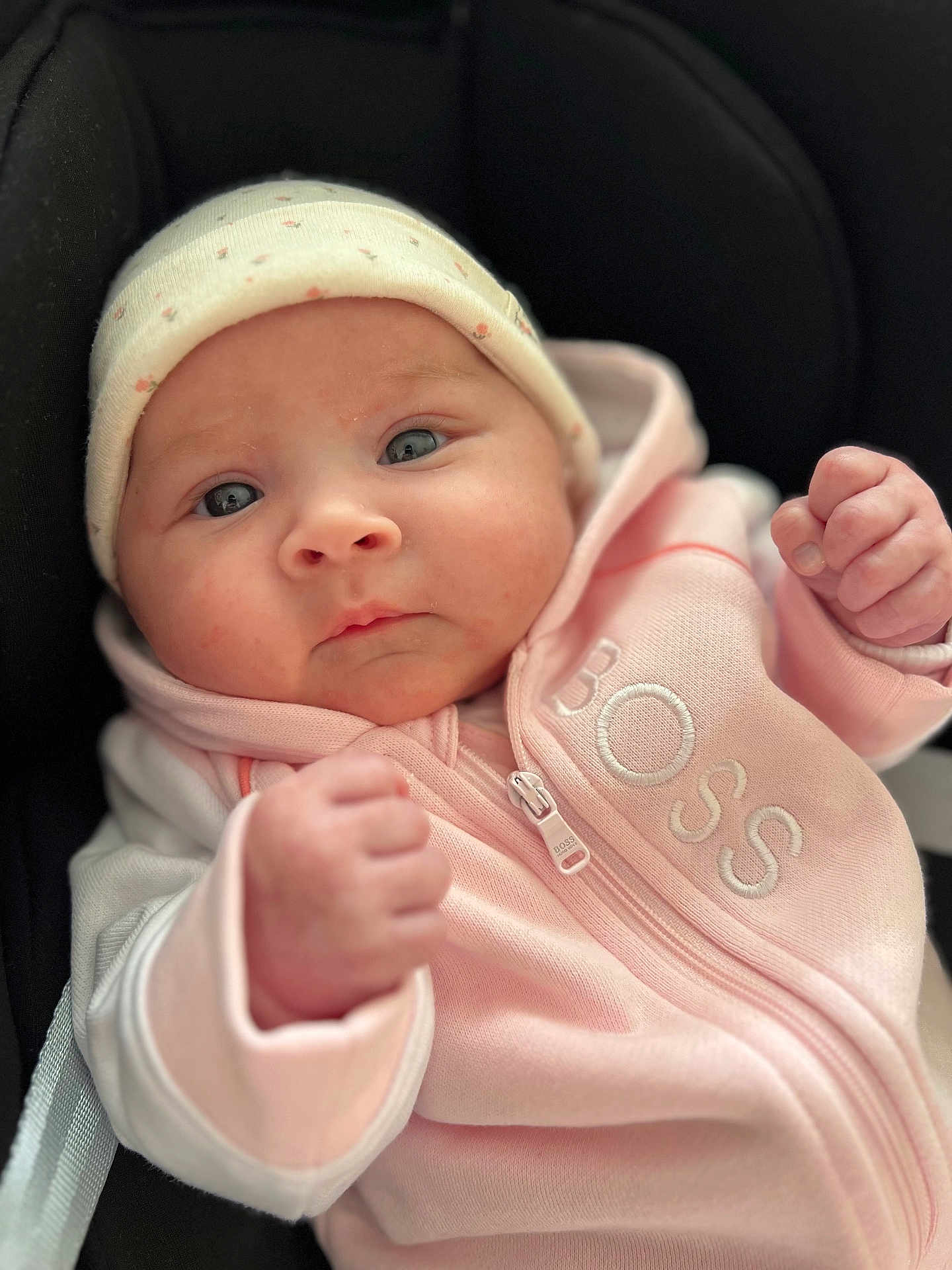 Paola participe au concours pour gagner de l'argent avec cette photo : baby, infant, face, hat, hoodie, pink_clothing, fist, cute, child, portrait, closeup, person, newborn, expression, apparel, casual_clothing, warm_clothing, indoor, soft_lighting, young_child