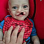 baby, child, cleft_lip, red, blue, spiderman, bib, hand, seat, infant, close_up, smiling, person, cute, portrait, young, indoor, clothing, human, face