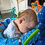 Micky is registered to the contest to win money with this photo: baby, infant, sleeping, blue, baby_seat, toy, colorful, indoor, child, face, head, clothing, peaceful, nap, cute, soft_light, closeup, young, resting, playtime