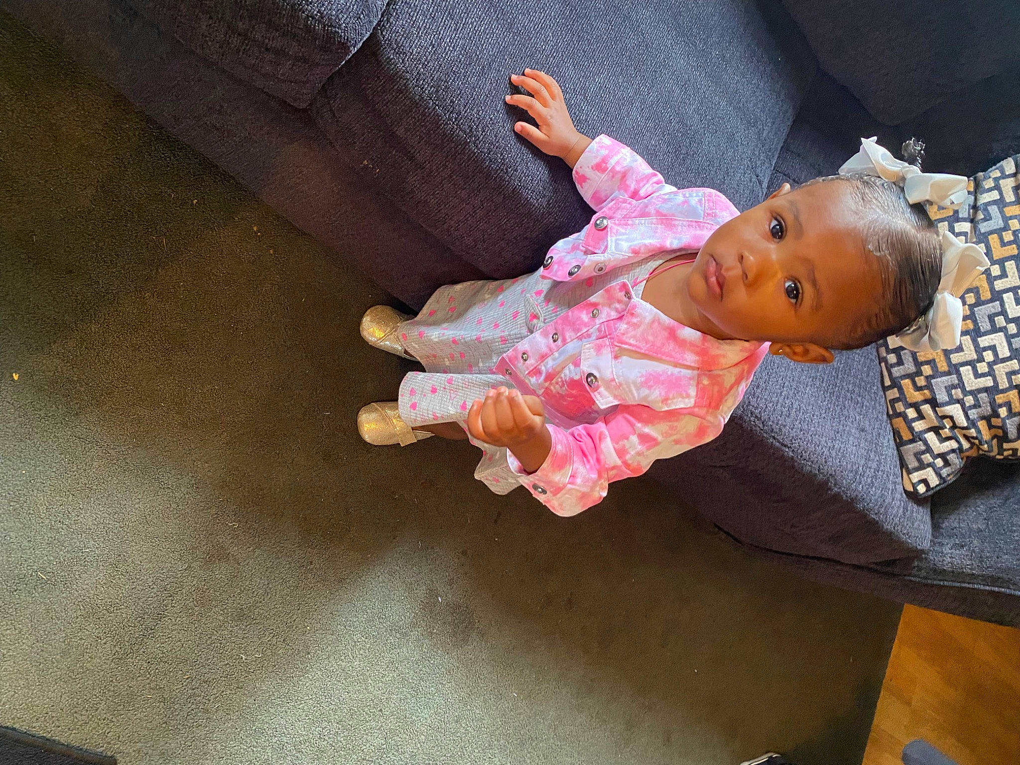 Zaira is registered to the contest to win money with this photo: baby, baby_products, baby_toddler_clothing, cheek, child, comfort, floor, flooring, foot, hardwood, hat, human_body, human_leg, linens, person, room, sitting, sleeve, thumb, toddler