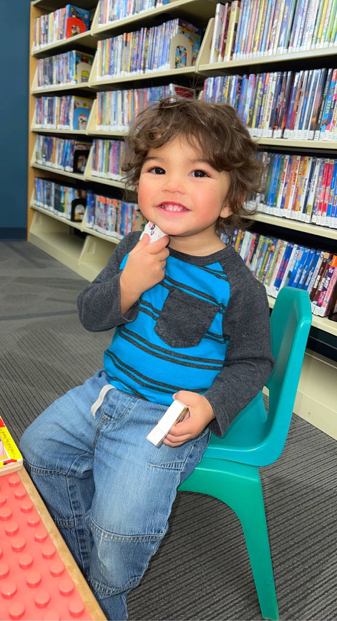 Kyree joined the competition — help win amazing prizes! blue, book, bookcase, chair, floor, flooring, furniture, hair, hairstyle, jeans, joy, leg, person, photograph, product, publication, retail, shelf, shelving, smile