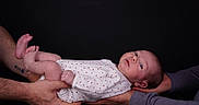 Yvana participe au concours pour gagner de l'argent avec cette photo : baby, infant, hands, onesie, red_hearts, white_clothing, skin, portrait, newborn, cute, human, child, holding, people, studio, black_background, expression, looking, small, tenderness