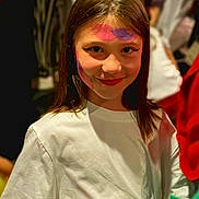 Layana participe au concours pour gagner de l'argent avec cette photo : blurred_background, casual_clothing, child, colorful, eyeliner, face_paint, festival, girl, hair, happy, indoor, makeup, people, person, portrait, red_lipstick, smile, social_event, white_tshirt, young