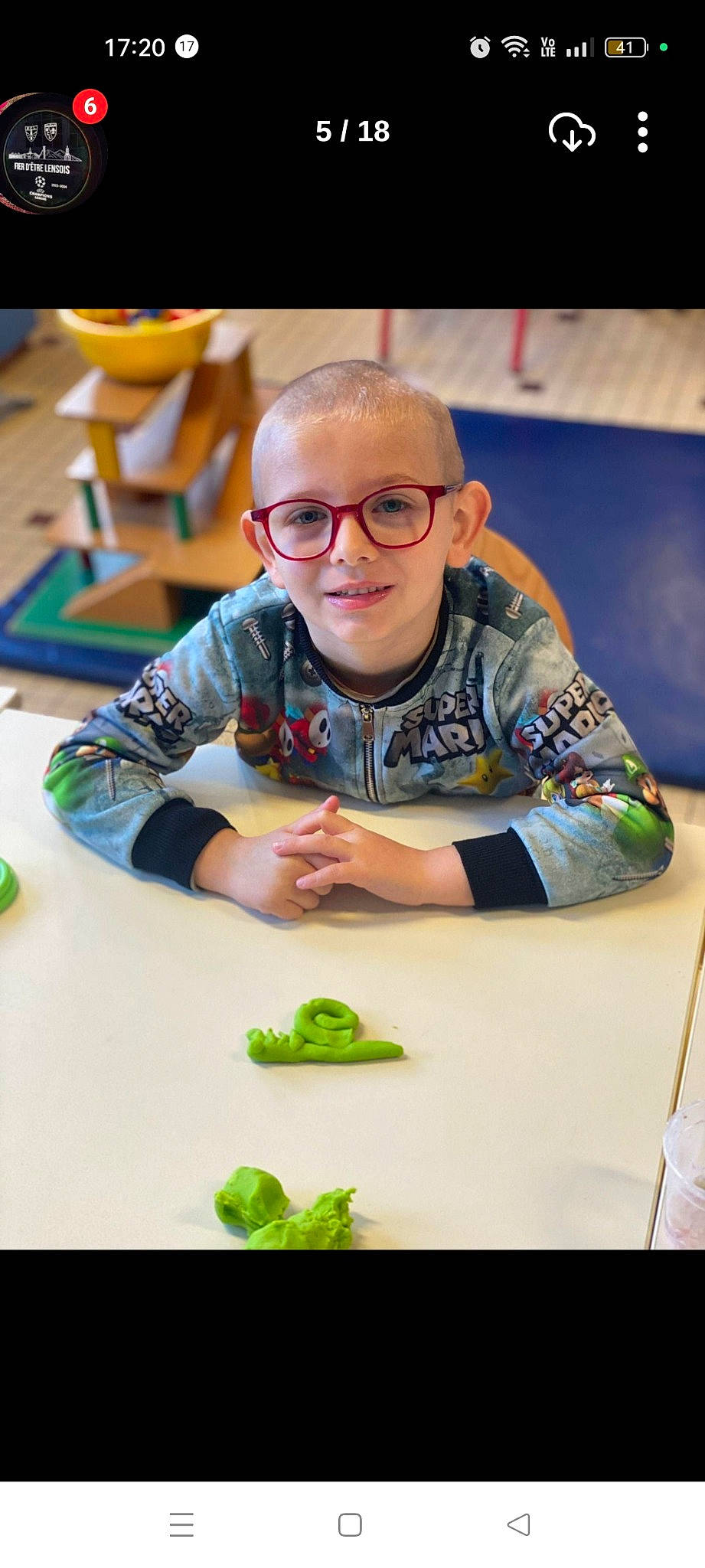 Taho participe au concours pour gagner de l'argent avec cette photo : chair, child, event, eyewear, flooring, fruit, fun, glasses, green, indoor_games_and_sports, joy, leisure, person, play, recreation, room, sitting, smile, t_shirt, table