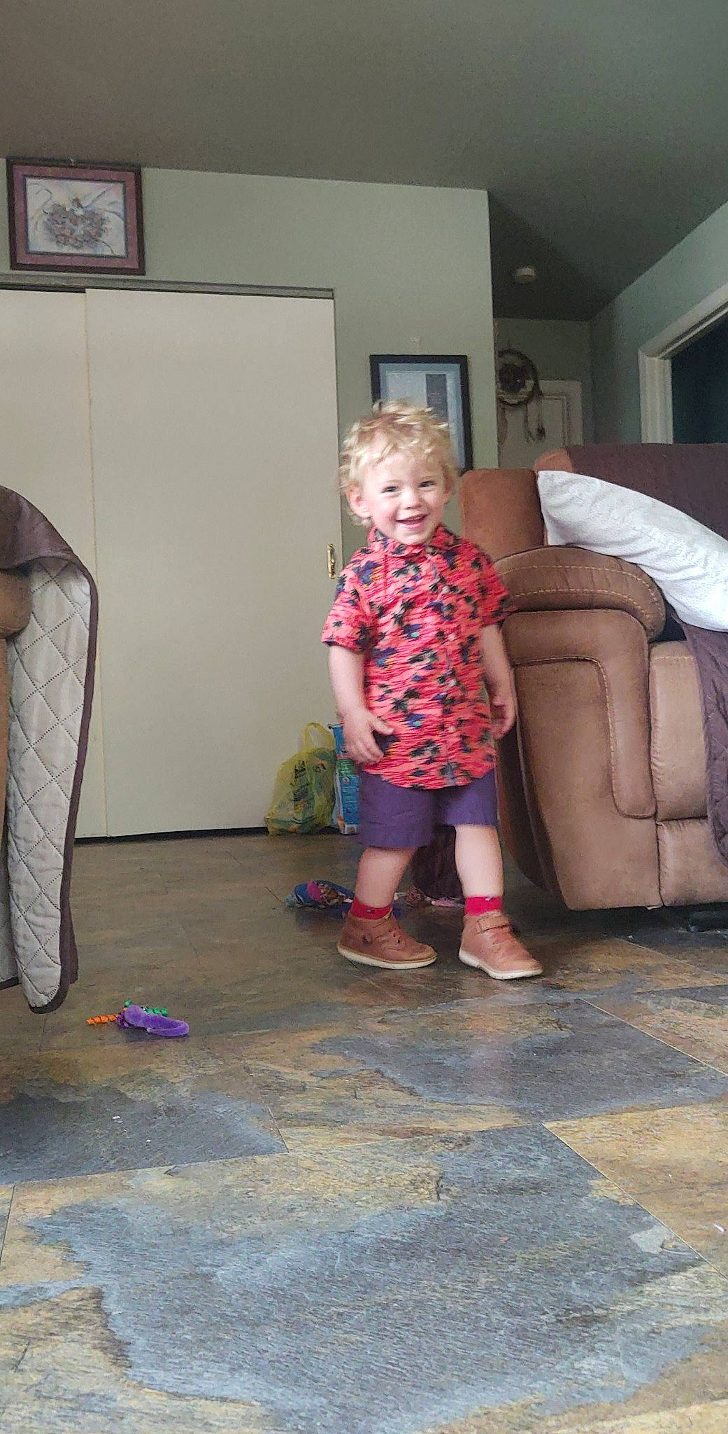 Derek is registered to the contest to win money with this photo: boot, child, couch, floor, flooring, fun, hardwood, human_leg, joint, joy, leisure, living_room, person, picture_frame, play, sandal, sitting, smile, sock, standing