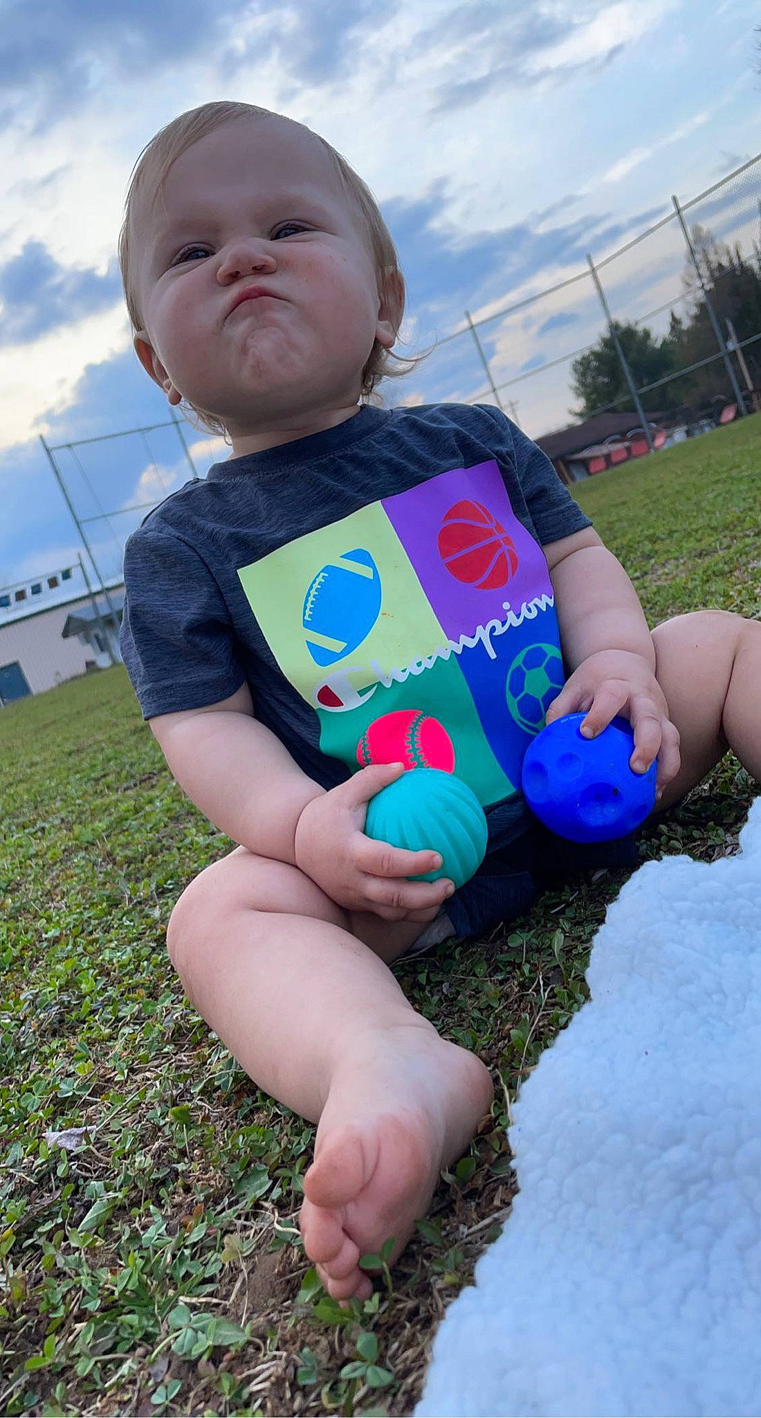Elikai is registered to the contest to win money with this photo: baby_toddler_clothing, child, cloud, electric_blue, finger, foot, fun, grass, happy, human_leg, leisure, people_in_nature, person, personal_protective_equipment, play, recreation, sky, t_shirt, thigh, thumb