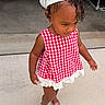 toddler, child, girl, red_and_white_checkered_dress, headscarf, curly_hair, earrings, shoes, concrete, sidewalk, outdoor, walking, cute, fashion, portrait, person, young_child, summer, sunlight, innocence