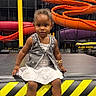 Nova joined the competition — help win amazing prizes! toddler, child, indoor_playground, slide, colorful, vest, white_dress, shoes, play_area, fun, smiling, curly_hair, platform, yellow_black_stripes, casual_clothing, young_child, sitting, playground_equipment, cute, portrait