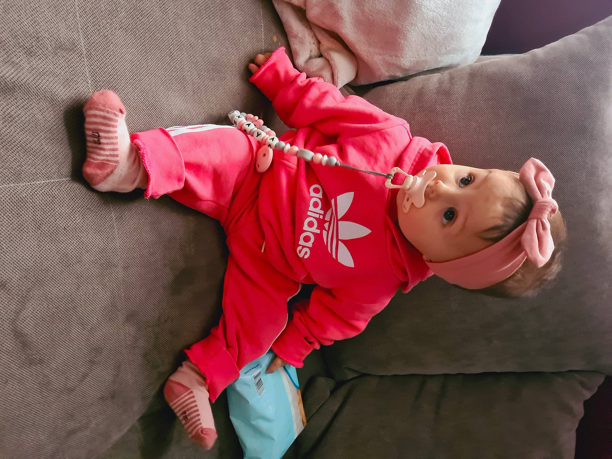 Inaya a rejoint le concours — aidez-le/la à gagner de superbes lots ! arm, baby, baby_products, baby_toddler_clothing, child, comfort, eye, face, finger, fur, hat, head, human_body, magenta, person, pink, skin, sleeve, sock, surprise