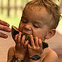 child, toddler, watermelon, fruit, eating, hands, bracelet, temporary_tattoo, tattoo, skin, face, hair, mouth, summer, outdoor, blurred_background, hand, closeup, expression, food